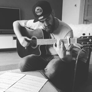 Gitaarleraar Teon Brama speelt akoestische gitaar